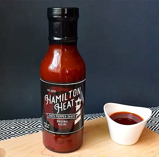 A bottle of Original Datil Pepper Hot Sauce beside a dish of the sauce