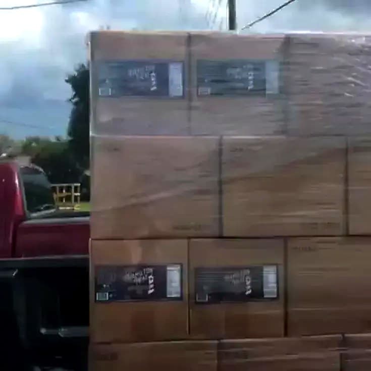 The first pallet of Hamilton Heat, stacked and shrink-wrapped behind a pickup truck